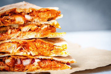Quesadilla with chicken and cheese. Close-up, dark background.