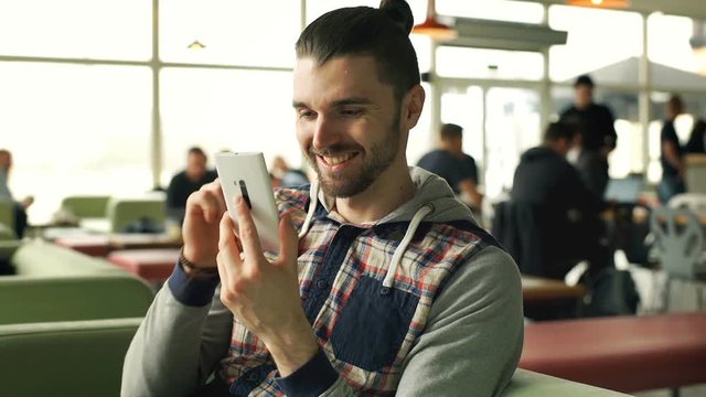 Man browsing internet on smartphone and receives good news, steadycam shot
