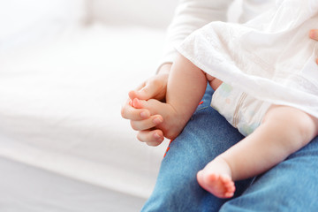 Young mother and newborn baby in white bedroom