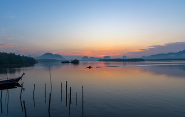 Beautiful sunrise landscape view of fisherman and wooden boat in early morming at Samchong-tai fishing village in Phang-Nga,Thailand