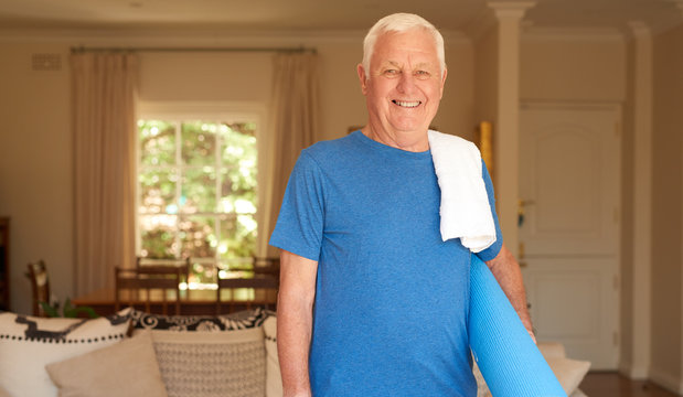 Active Senior Man Standing At Home Prepared To Do Yoga 