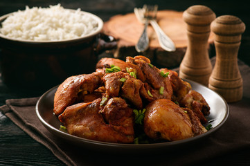 Chicken pieces baked in tomato sauce and boiled rice.