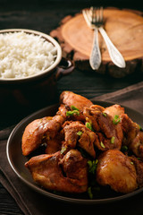 Chicken pieces baked in tomato sauce and boiled rice.