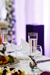 Champagne flute decorated with little branch stands on dinner table