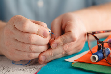 Obraz premium colorful sewing threads on spools with needle