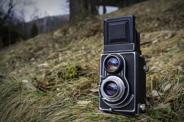 Old vintage analog photo camera in nature grass background