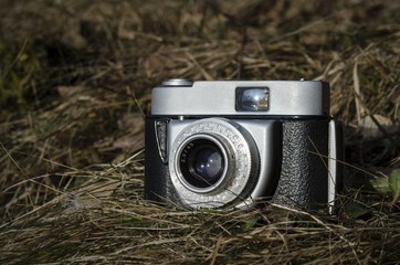 Old vintage analog photo camera in nature grass background