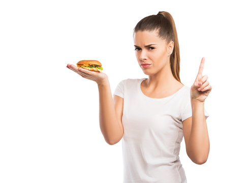 Beautiful woman holding a cheeseburger, saying NO to unhealthy, fast food
