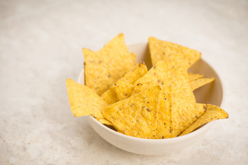 Delicious nachos with cheese on the white wooden background. Shallow depth of field.