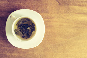 Green tea and leaves on rustic wooden table