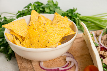 Delicious nachos with cheese on the white wooden background. Shallow depth of field.