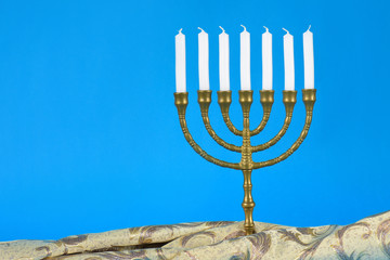 Sieben armiger Leuchter Kerzenständer jüdische Tradition mit kostbarem Stoff auf blauem Hintergrund