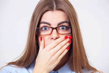  Young business woman holding her hand near mouth isolated on gray background.