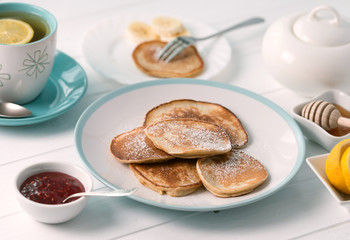Pancaked powdered with sugar, jam and honey
