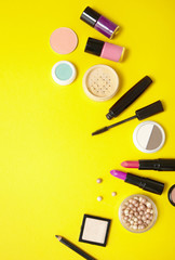 Make up and cosmetic beauty products arranged on a vibrant yellow background