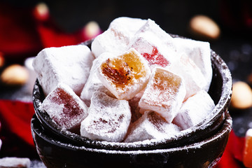 Rahat lokum with rose petals, walnuts and  sugar powder, selective focus