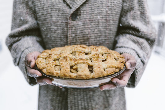 Man holding apple pie on winter snowy day