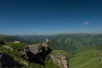 Landscape, the girl on a background of mountains in the summer