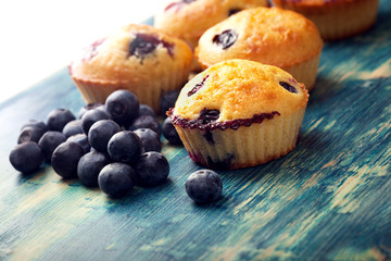 muffin with blueberries on a wooden table. fresh berries and sweet pastries on the board.