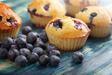 muffin with blueberries on a wooden table. fresh berries and sweet pastries on the board.
