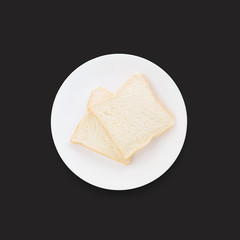 Closeup two slice bread on white dish for breakfast with shadow isolated on black background in top view