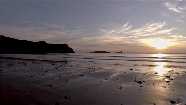 Worms Head at sunset at Rhossili beach on the Gower peninsula, Swansea, UK