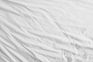 Top view of unmade bedding sheets or white fabric wrinkle texture background