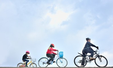 青空のサイクリングを楽しむファミリー
