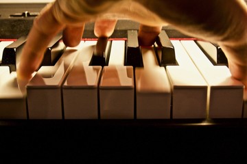 hand playing chord on piano