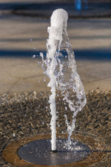 Naklejka na ściany i meble running water from a fountain in the park