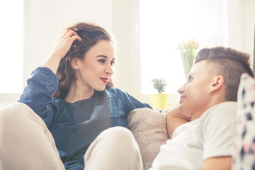 Loving couple looking at each other and talking home interior