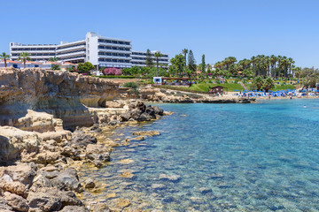 Fototapeta premium Hotel relaxing zone with palm trees and sea view in protaras, cyprus island, rocks and immaculate water