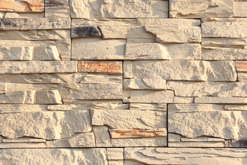 Wall of decorative stone sand color. Background of artificial stone