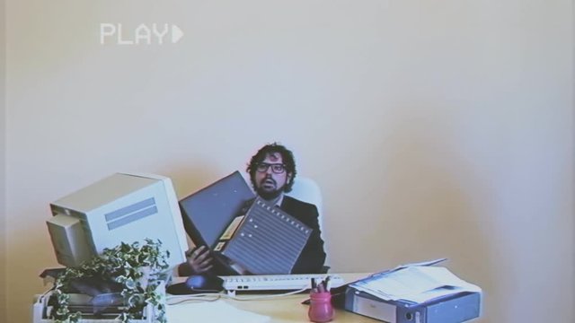 Fake VHS tape: a male employee gets loads of work from his female coworker.
