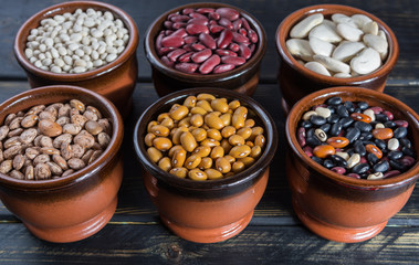 Assortment of beans on wooden background. Soybean, red kidney bean, black bean,white bean, red bean and brown pinto beans