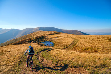 Mountain biker riding the bike on the trail to horizon line.  Extreme sport concept.