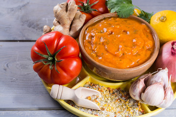 Bowl of spicy vegetable orange Tikka Masala sauce and all the ingredients that go into making it.  Used widely in Asian food.