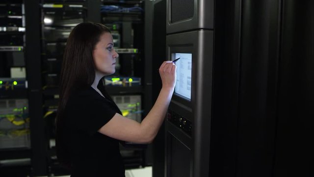 Woman walking up to computer server and inserting disk