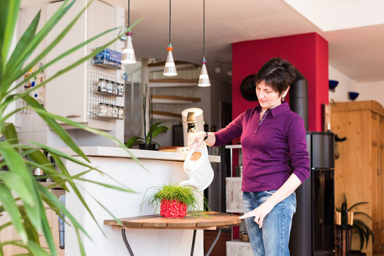 Senior Woman Watering Plants