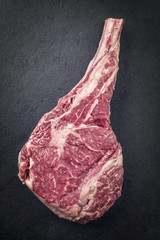 Raw dry Aged Wagyu Tomahawk Steak on a Slate