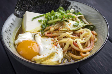 Traditional Japanese Ramen Soup with Tofu and Egg as close-up in a Bowl
