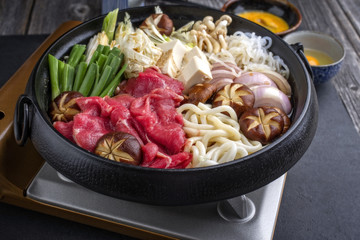 Traditioneller japanischer Sukiyaki Eintopf mit Kobe Fleisch und Gemüse auf einem Gaskocher