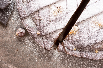 Chocolate Tart Pie Topped with Hazelnuts and Sprinkled with Powdered Sugar