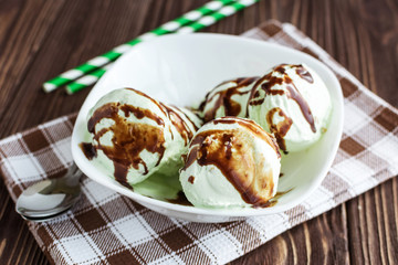 Pistachio ice cream with chocolate on a rustic background