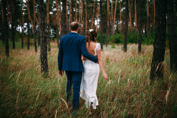 The bride and groom walking in the wood