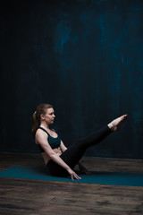 Obraz premium Yoga woman practicing on blue mat indoors