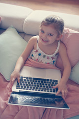 Little girl using her laptop.