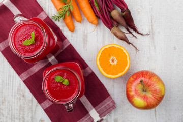 Vegetable and fruit cocktail, served in a jar, with fresh beets, carrots and apples.