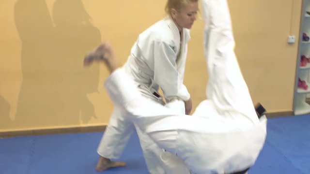 Man and woman demonstrate the technique Aikido school of martial arts, slow motion.