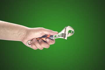 Man's hand holding big wrench